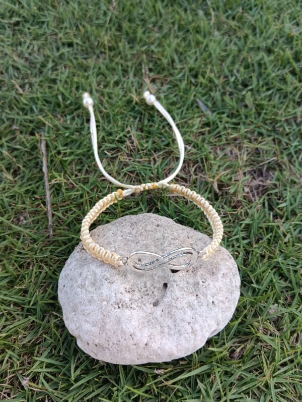 Pulsera tejida con dije plateado de infinito